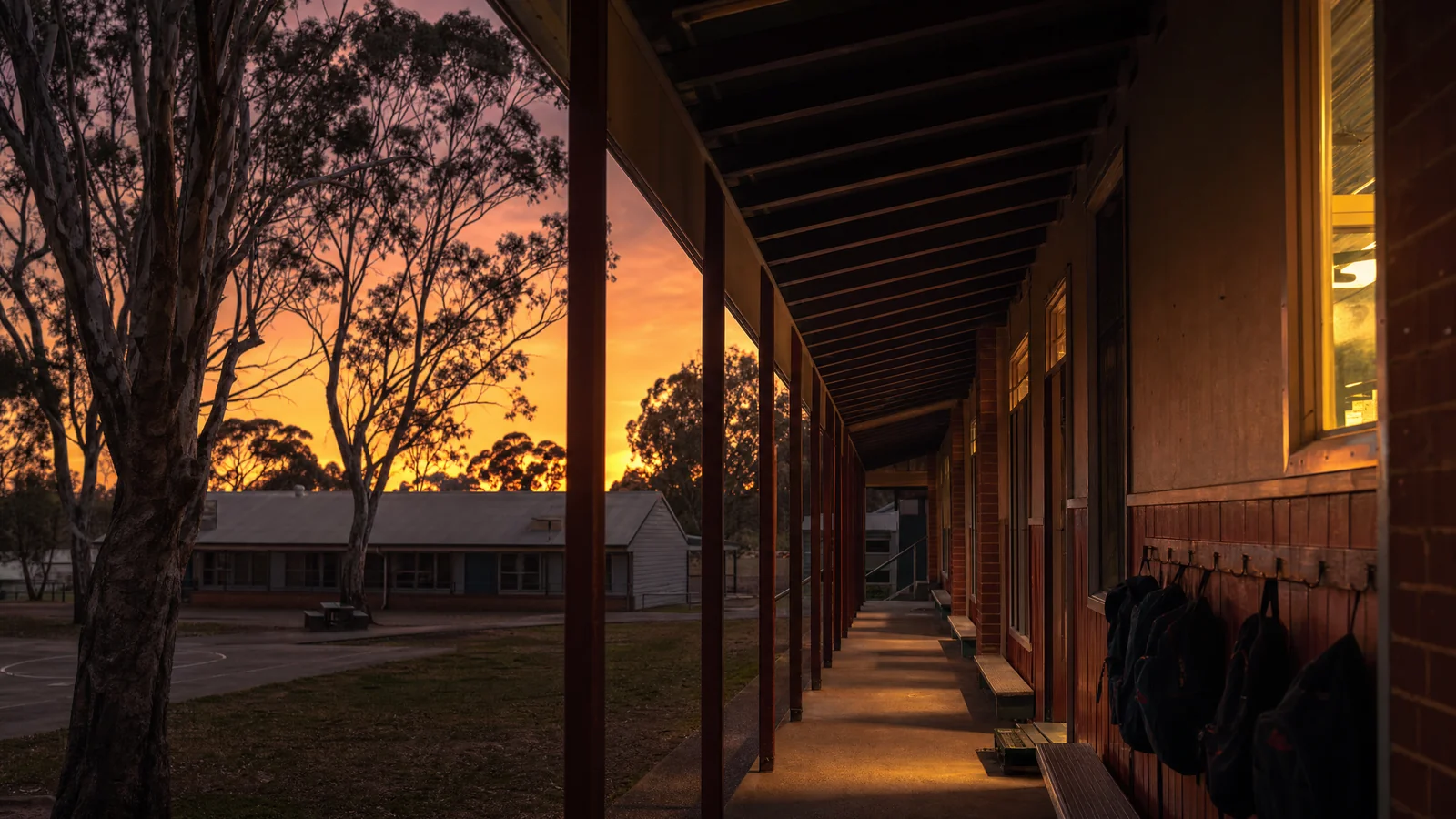 Empty school veranda at dusk with gum trees against the evening sky