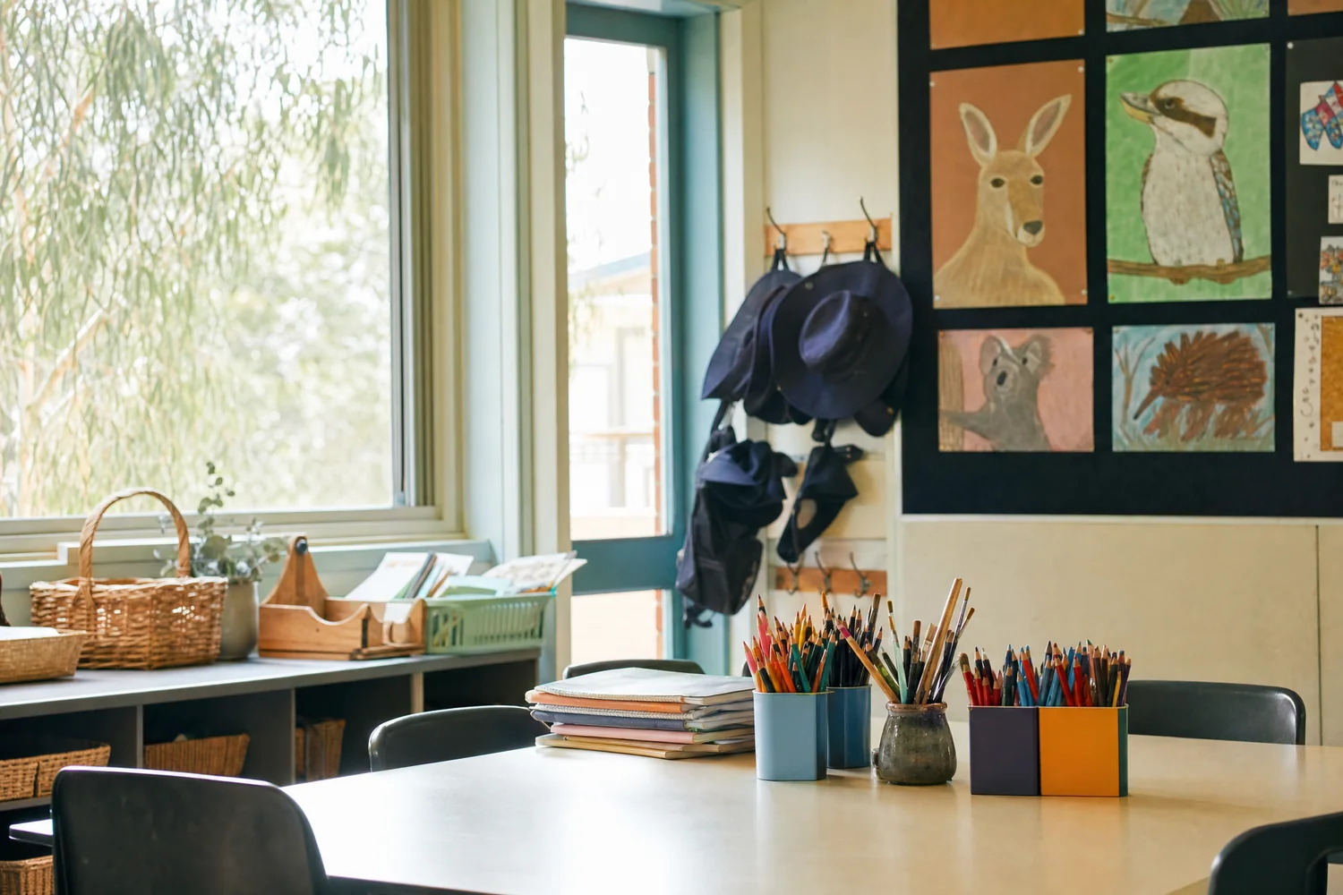 Australian primary classroom with school hats on hooks and artwork of native animals