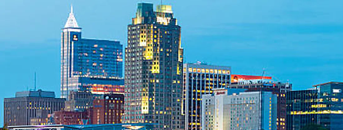 The Raleigh skyline at night with PNC Plaza and the Convention Center